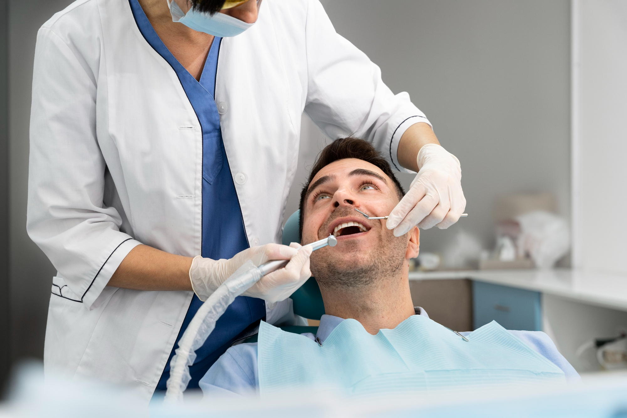 Dentist explaining a dental implant model to a patient